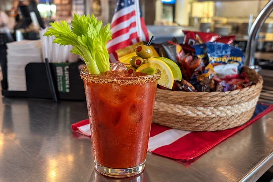 Bloody Mary cocktail with celery, olives, and citrus garnish on the bar counter at Miller's Tavern in Sun City Summerlin, Las Vegas.